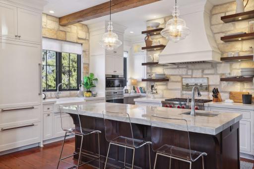 The kitchen has a custom walnut center island with marble countertop and undermount sink. You'll appreciate the custom cutting boards with garbage stations throughout.