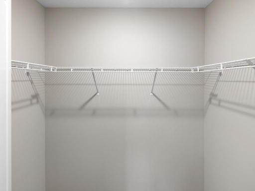 Primary Suite Walk In Closet. Photo is taken of another home with similar plan and finishes.