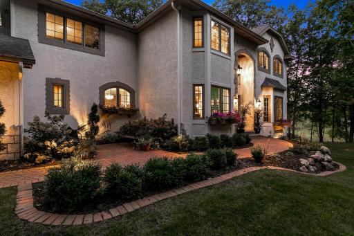 A charming, newly installed paver patio leads up to the front entry of the home.
