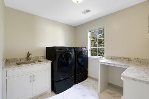 The spacious and bright upper level laundry offers convenience and additional storage.