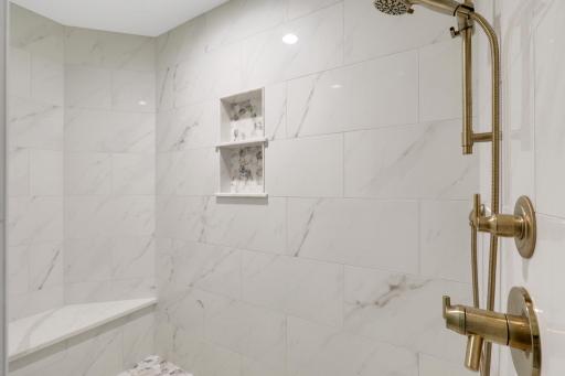 A luxurious private bathroom features heated floors, a massive walk-in shower, a separate soaking tub, separate double vanities with fog resistant LED mirrors, and a private commode room.