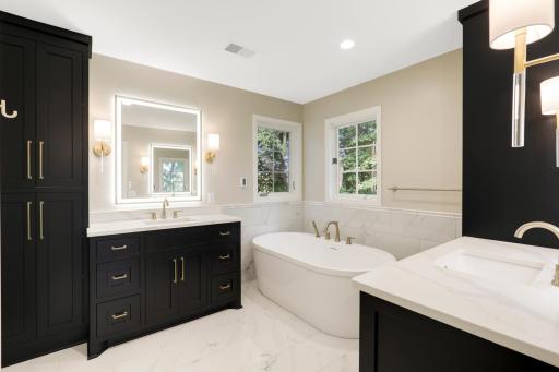 A luxurious private bathroom features heated floors, a massive walk-in shower, a separate soaking tub, separate double vanities with fog resistant LED mirrors, and a private commode room.
