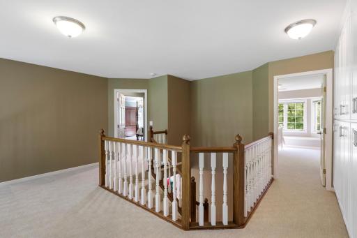 The upper level offers four spacious bedrooms, a large laundry room, and a wide catwalk that interacts with the main floor.
