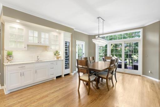 The dining room features a wet bar with built-in cabinetry and a wine fridge.