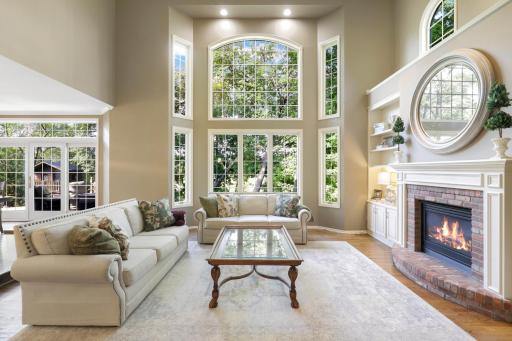 The main floor living room features a stunning 2-story wall of windows looking out to the private backyard.