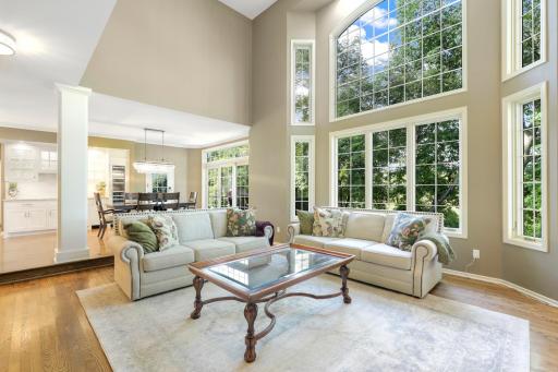 The main floor living room features a stunning 2-story wall of windows looking out to the private backyard.