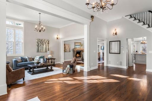 Step into the grand foyer, where a sophisticated chandelier and gleaming Mahogany wood floors set the tone for elegance and style.