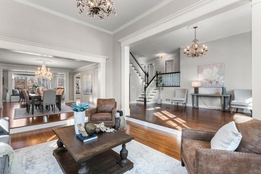 Adjacent to the foyer is the formal living area, boasting a 12-ft ceiling and a dazzling chandelier creating a space that is both warm and inviting.