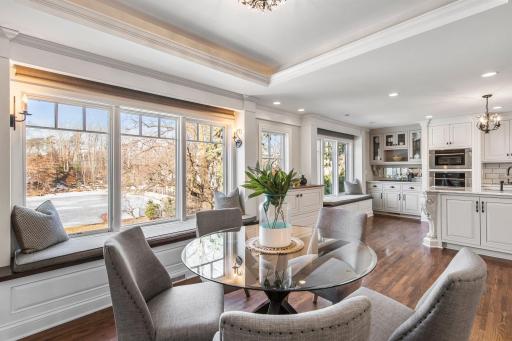Connected to the dining room is a charming sitting area featuring a coved ceiling, built-in window seating with picturesque views of the backyard.
