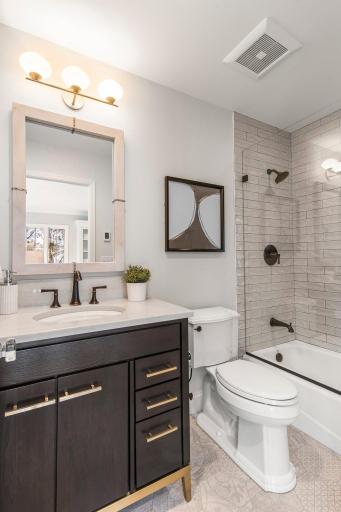 This space features a private full bathroom with heated tile flooring and beautiful tiled tub and shower combination.