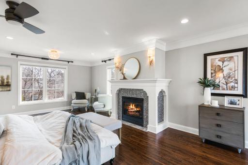 This luxurious bedroom features a cozy gas fireplace with penny tile surround.