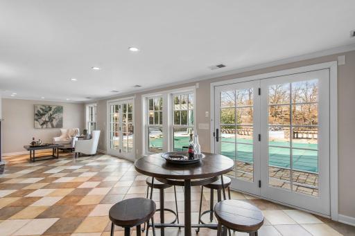 The lower level sunroom offers built-in bookshelves, large windows that flood the space with natural light while providing breathtaking views of the backyard.