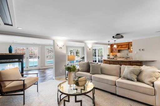 This family room is home to a projector with a remote-controlled screenâideal for movie nights and a 3 sided gas fireplace.
