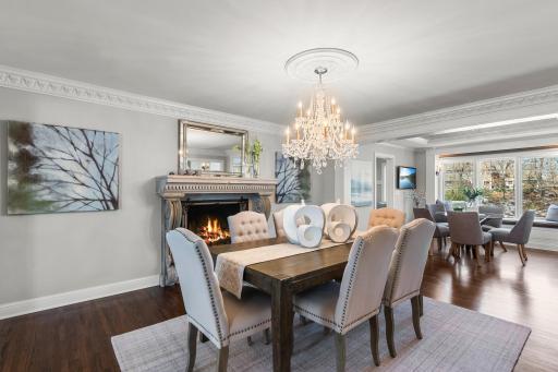 Flowing effortlessly from the living area is the formal dining room, highlighted by a magnificent chandelier and a gas fireplace with a breathtaking 100-year-old ornate concrete surroundâa true statement piece.