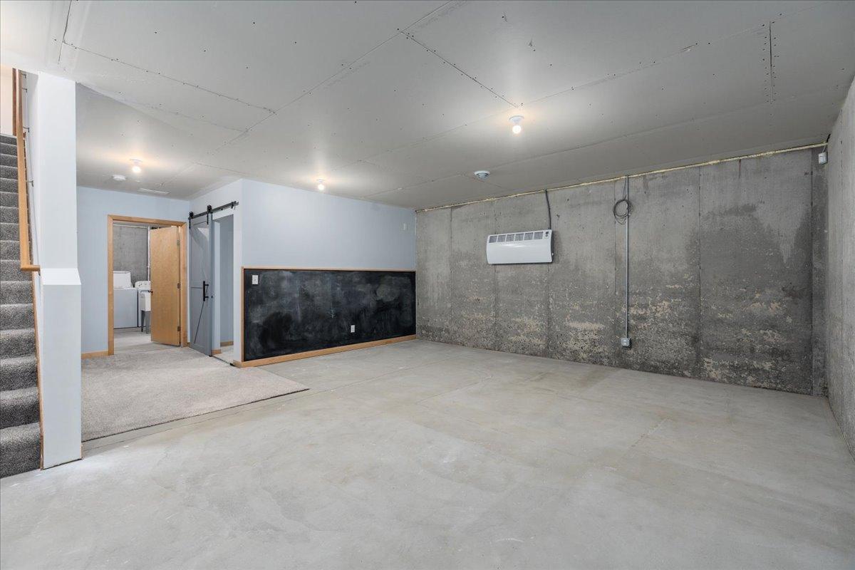 Unfinished lower level. Ceiling has been completely sheet rocked and there is a hardwired electric heater to keep it warm