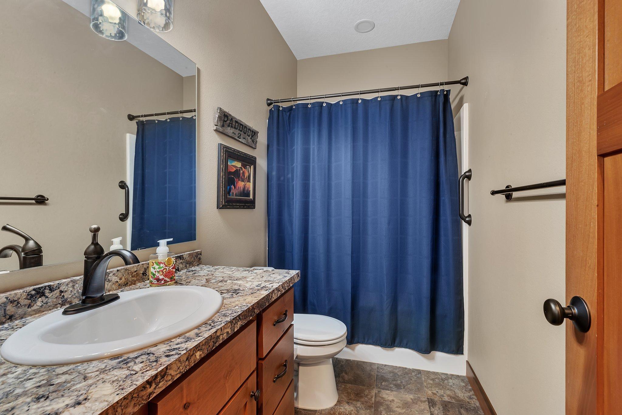 Shared full bath for guests and front bedroom spaces.