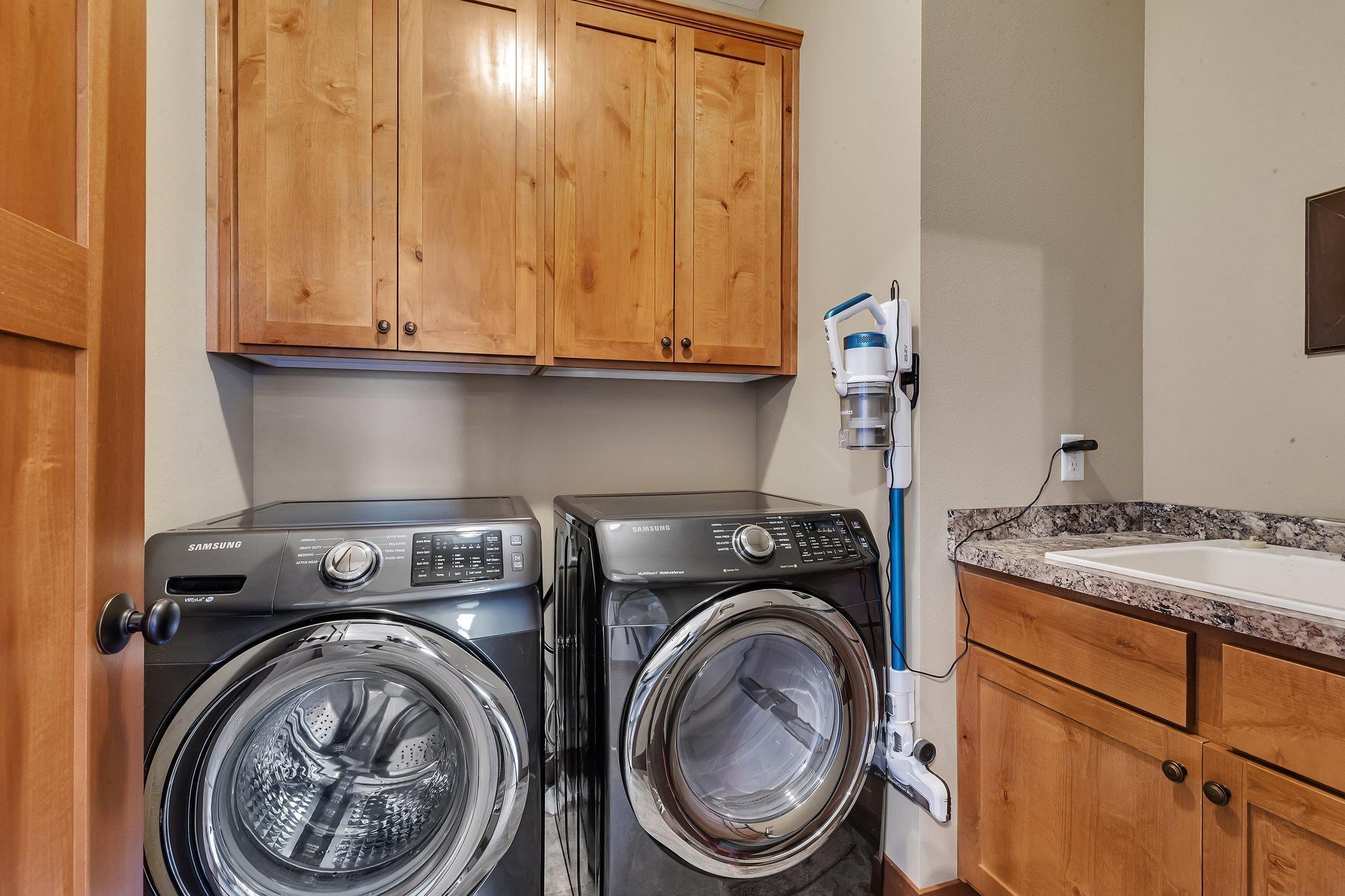 Efficient laundry area with storage and utility sink.