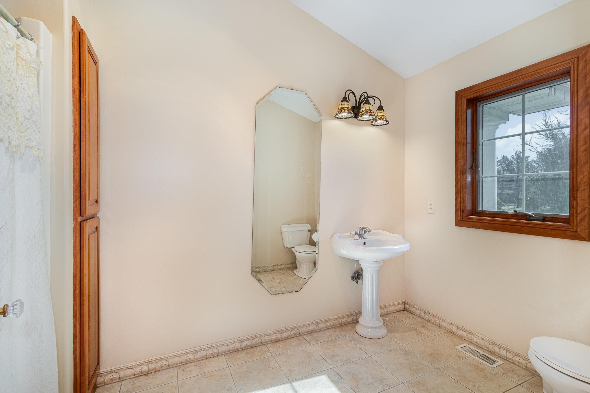 The main-level full bathroom features luscious tile flooring that adds a touch of elegance and durability.