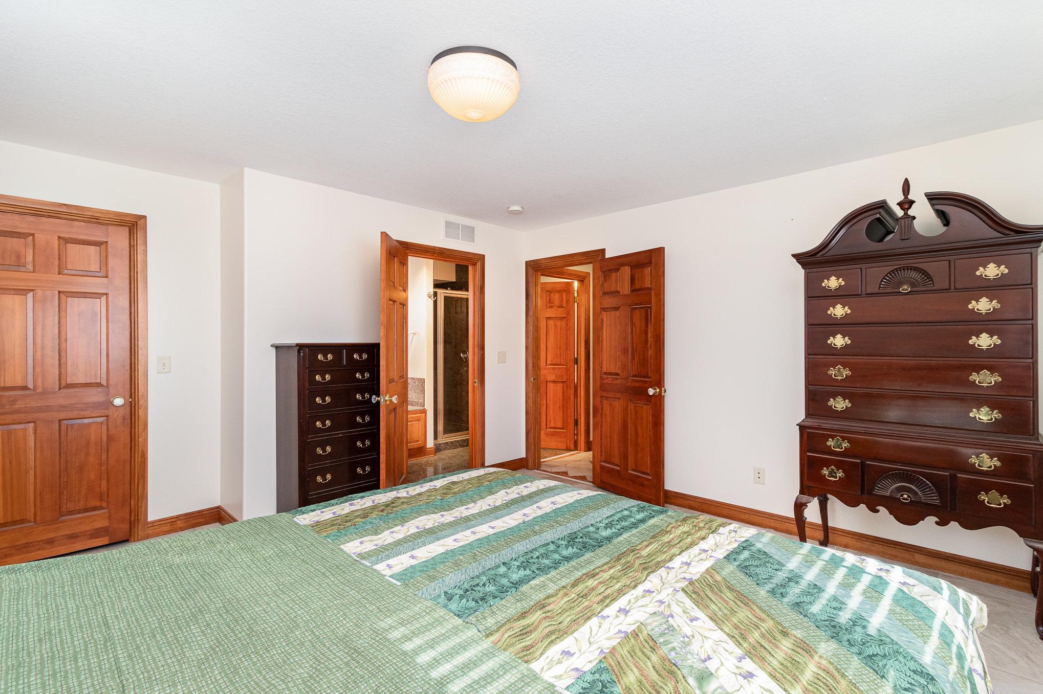 The adjoining master bath offers both convenience and luxury, with a large jetted tub, separate shower, and stylish finishes.