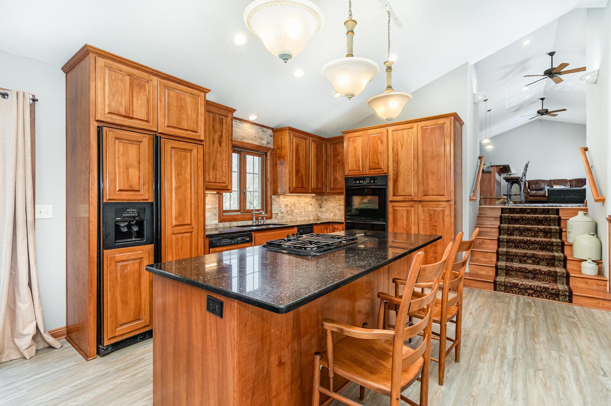 The kitchen is a chef’s dream, with a large center island, built-in 4-burner gas cooktop, and plenty of prep space.