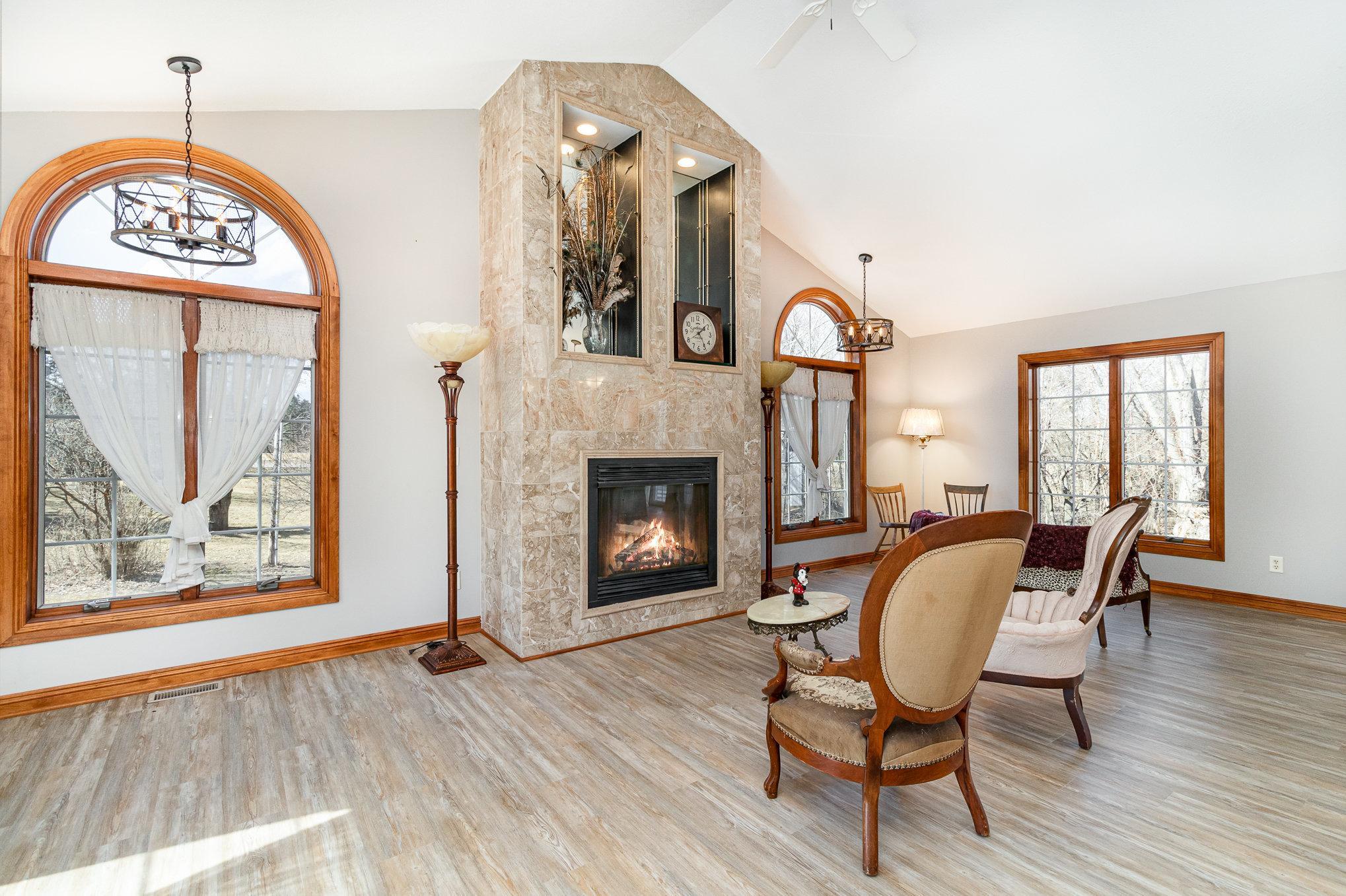 This fireplace feature is beautifully accented with mirrored insets and 2 large windows flanking each side of the fireplace enhances the sense of space and reflecting natural light throughout the room.