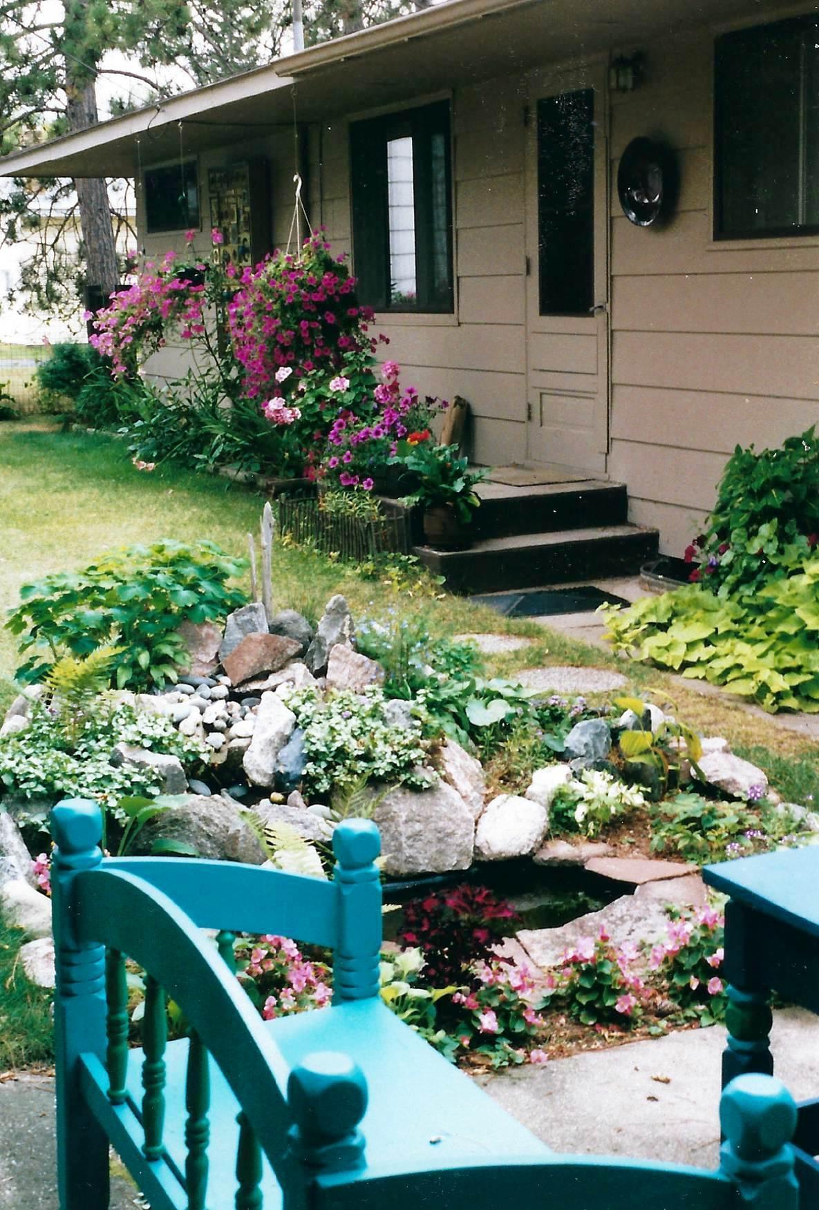 rock garden pond and gardens along backside of house.jpg