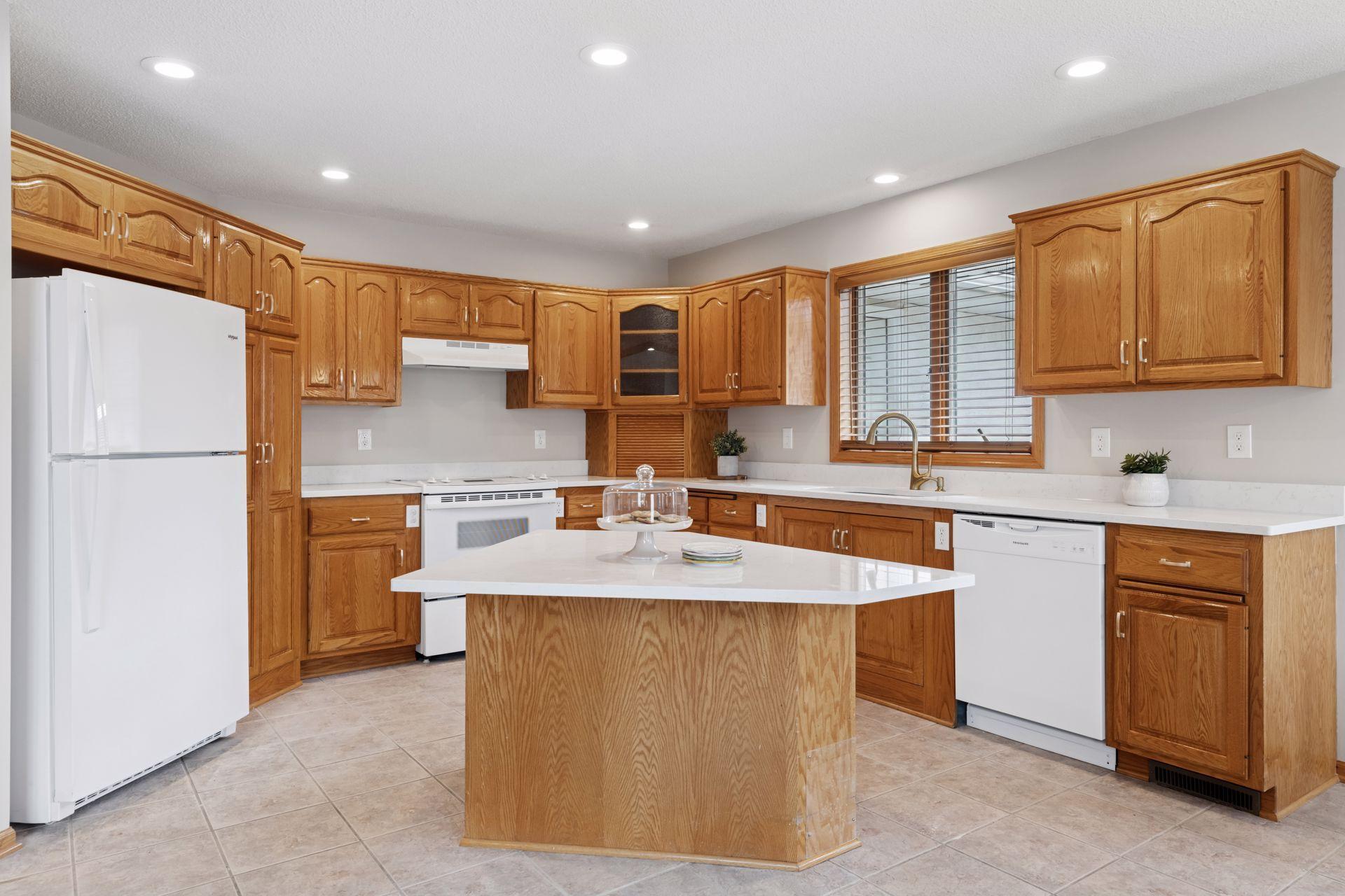 The kitchen is a chef’s dream, boasting sleek new white quartz countertops, pristine white appliances, and a spacious center island that offers both extra prep space and a casual dining spot.