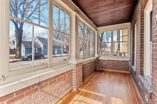 Front enclosed porch has beautiful original floors and a beadboard ceiling.