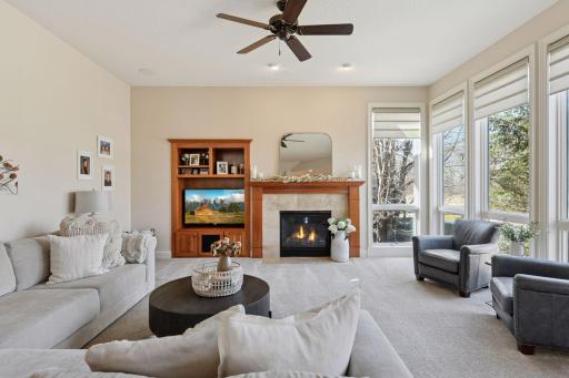 Main floor family room boasts floor to ceiling windows and a cozy gas fireplace.