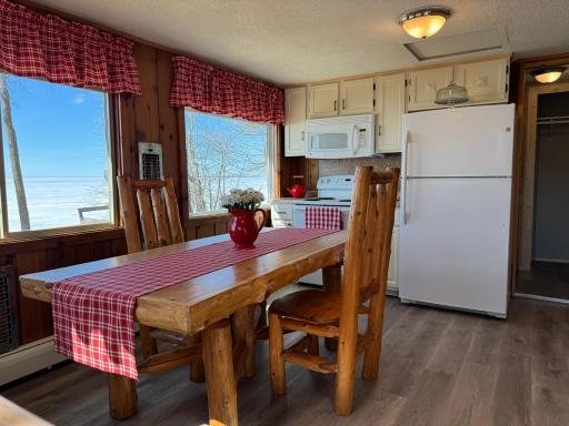 Another angle of the kitchen and dining room featuring VIEWS you won't be able to take your eyes off of! Lakeside wall offers 2 wall heaters that kick out a nice amount of warmth on those chilly mornings! Baseboard heat system needs new boiler.