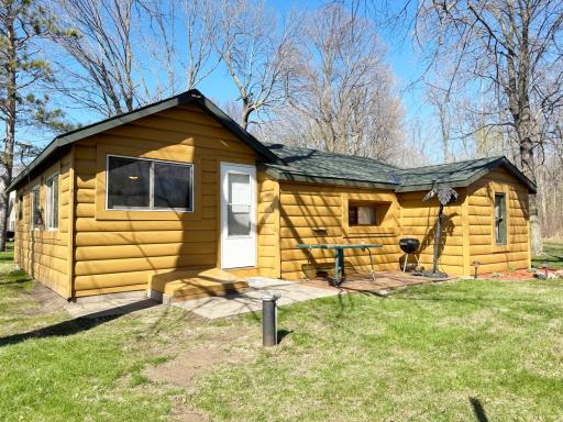 Side view shows cabin entry door on the south side that leads into the kitchen. Patio area for grilling and relaxing!