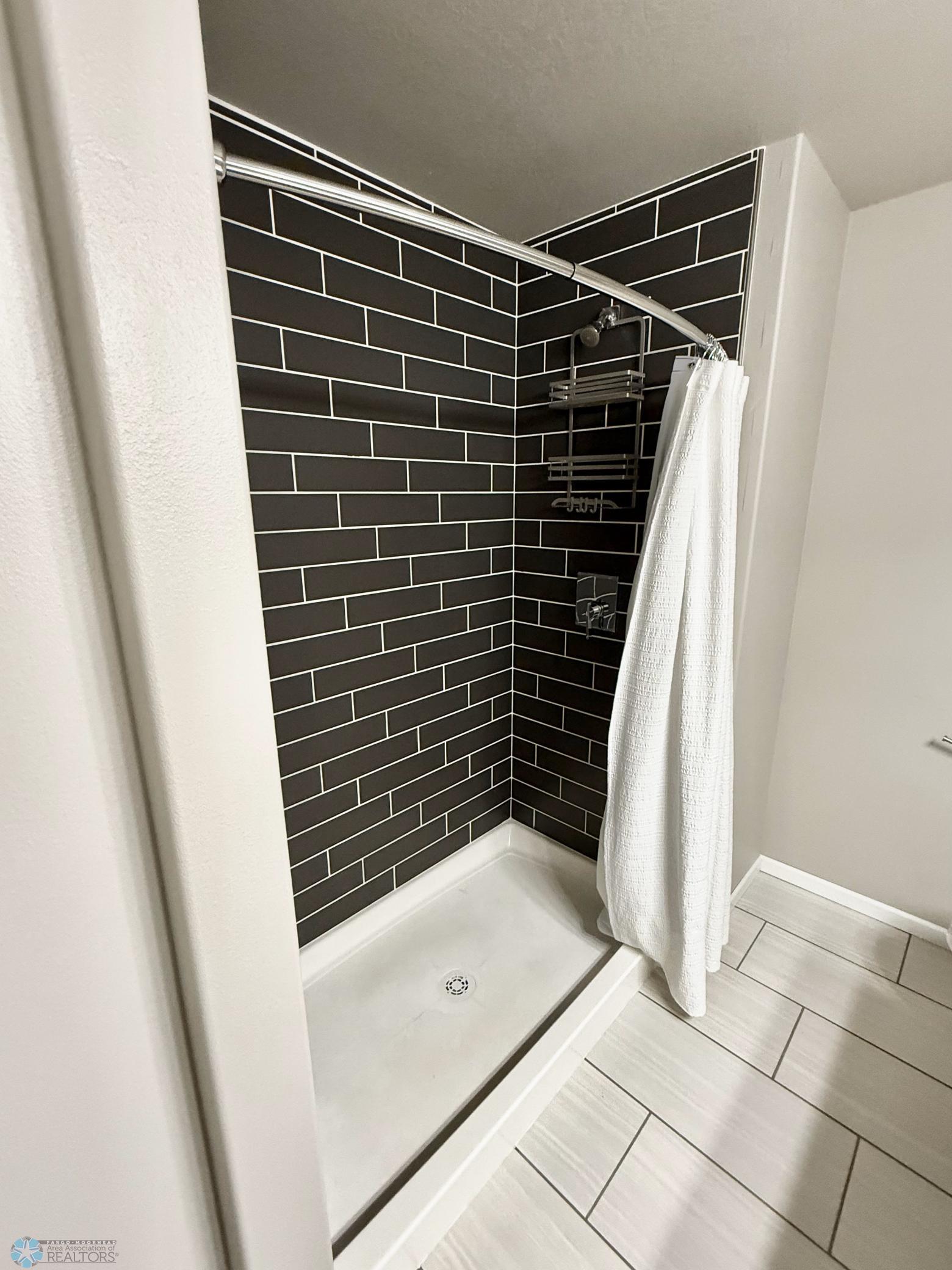 oversize subway tile in master shower.jpeg