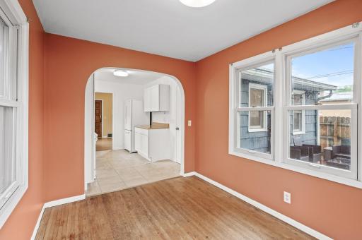 Dining room/Sunroom with oak hardwood floors. overlooking the wood fenced backyard