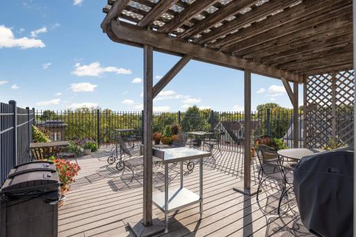 Rooftop setup with outdoor furniture and communal grill