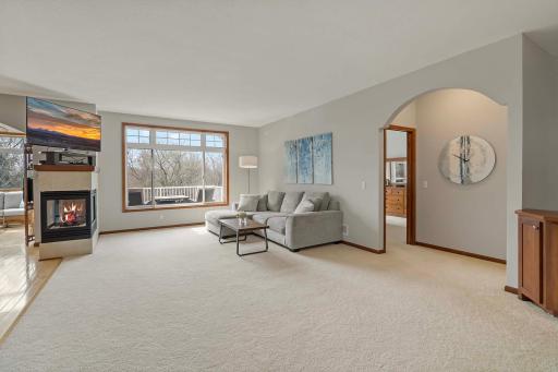 A three-sided gas-burning fireplace, large living space, and main level primary suite is tucked into the right of the photo.