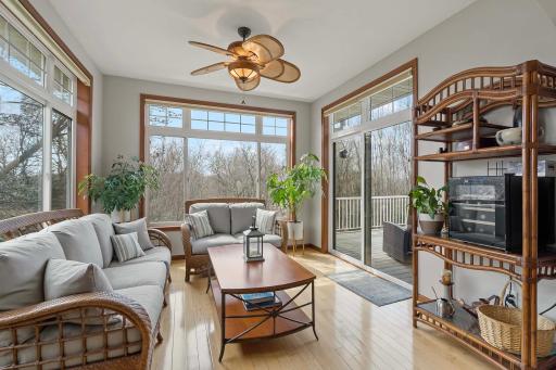 This bright sunroom is a highlight of the home. The sliding door opens to the maintenance-free deck that overlooks the wooded area behind the property.