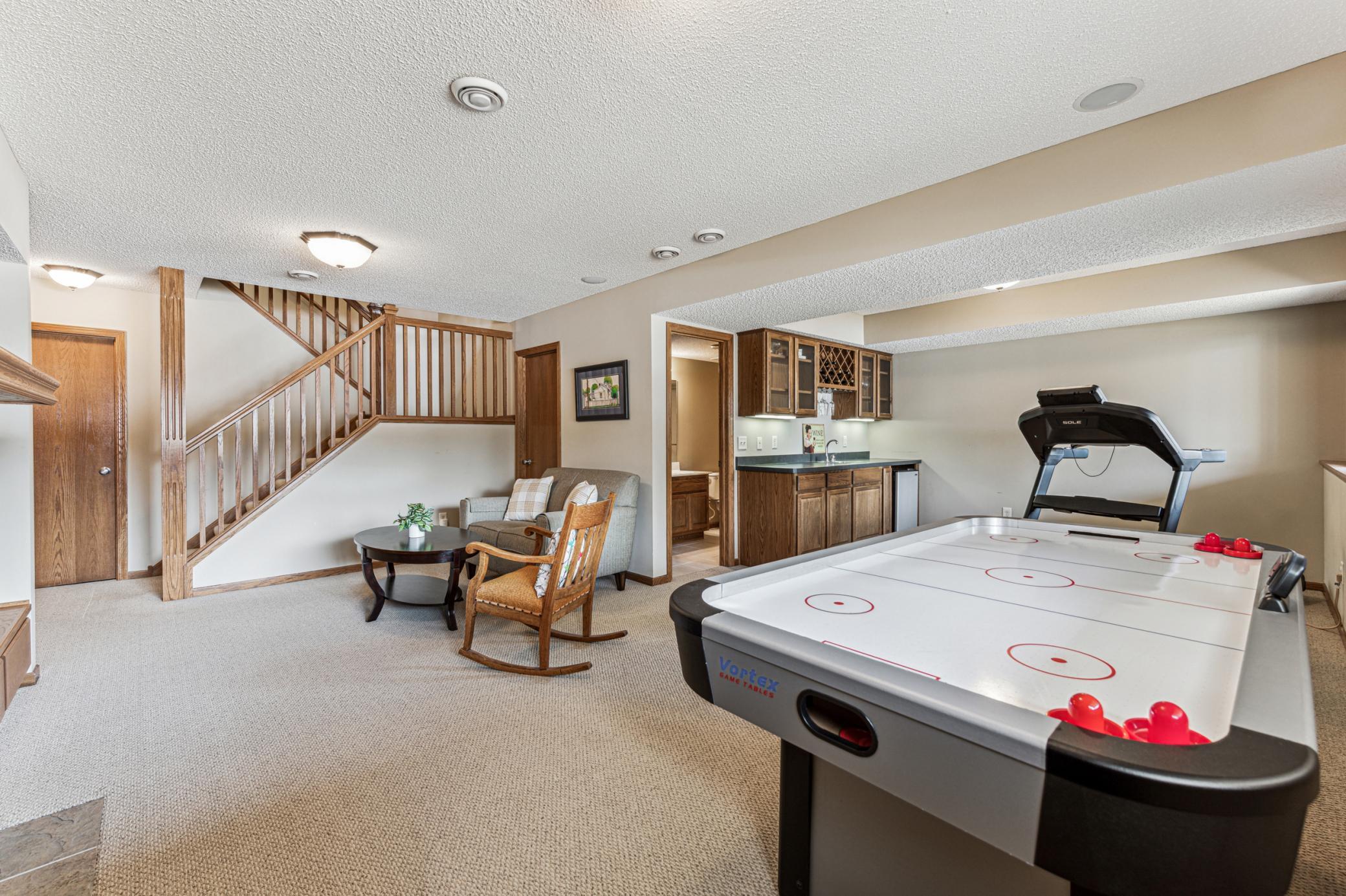 The lower level amusement room offers another spot to gather, play games and exercise. Entertaining is easy with the wet bar and fridge.