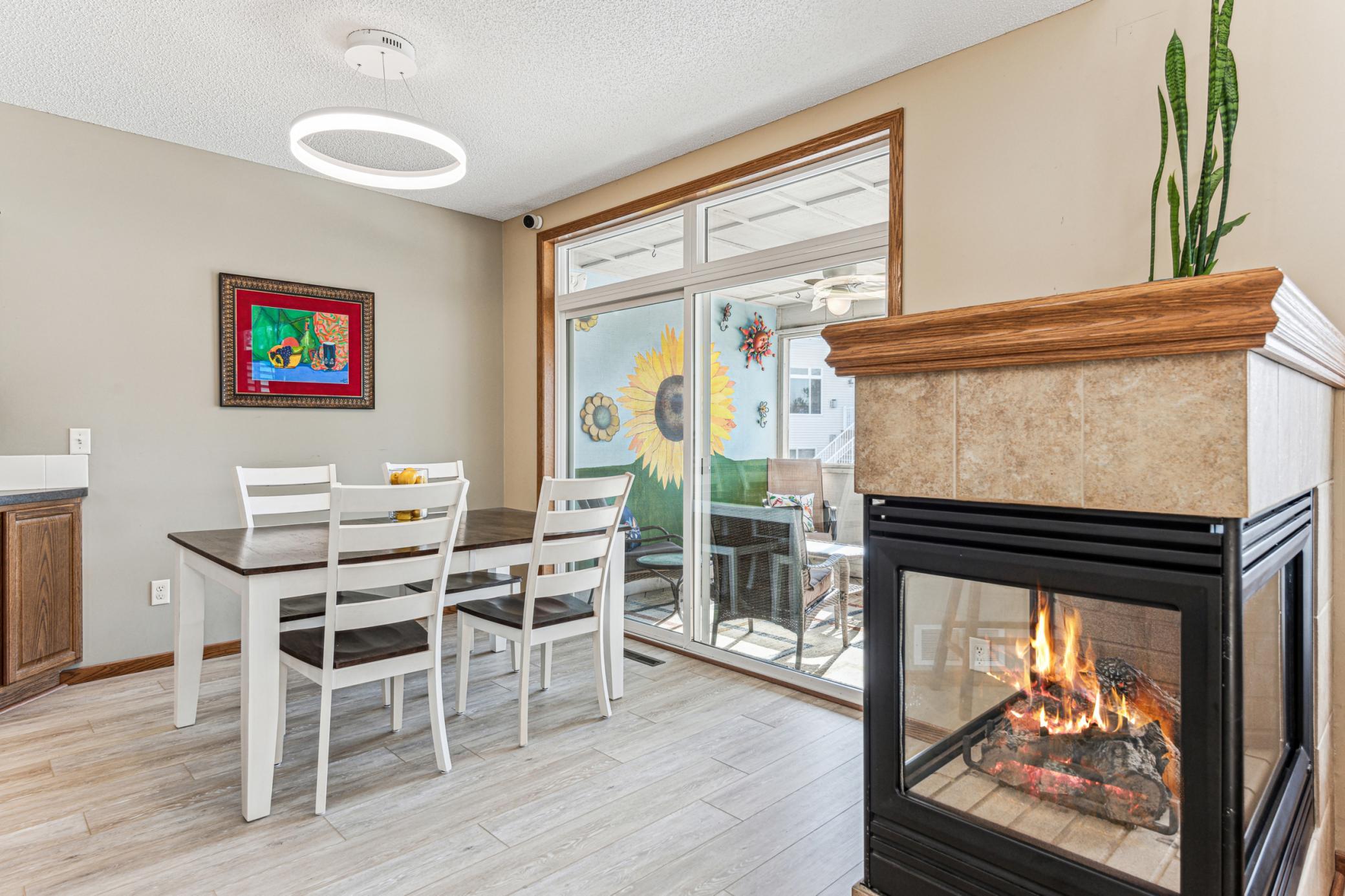 Three sided gas fireplace warms the space. Dining area walks out to the screened in porch.