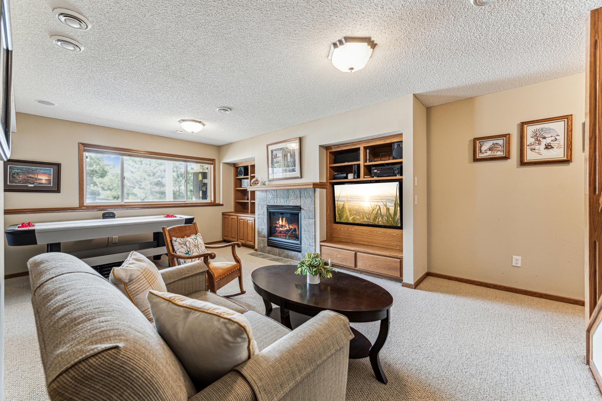 The look out windows provide plenty of light in the lower level. Custom built-ins for TV and storage.