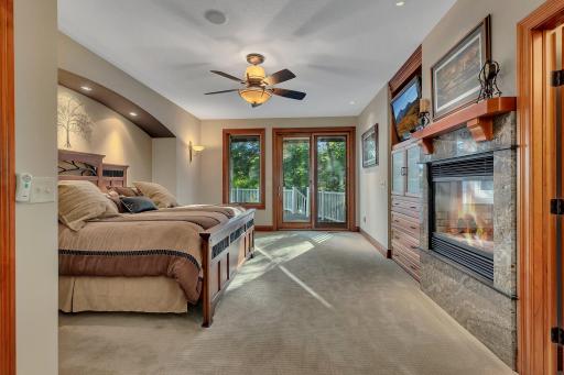 The main-level owners suite is a private sanctuary, offering direct access to the deck, a custom walk-in closet, and a double-sided gas fireplace that seamlessly connects to the spa-like en-suite bathroom.