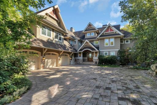 You are welcomed with exceptional curb appeal and an expansive paver driveway leading to a 3-car attached heated garage. It is surrounded by lush landscaping and elegant architectural details.