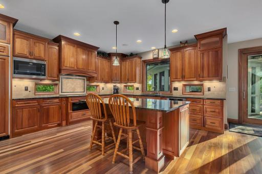 High-end appliances, beautiful hardwood floors, and elegant lighting complete this warm and inviting space.