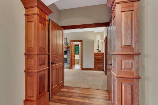The entrance to the main floors luxurious owners suite is framed by rich, custom millwork, creating an elegant and grand feel. As you step through the solid cherry doors, the suite opens into a serene retreat.