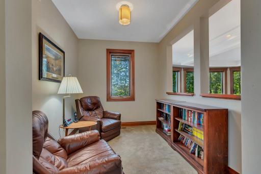 This cozy upper-level library nook offers a quiet retreat, perfect for reading or relaxing. This spot is ideal for unwinding with a good book while still being connected to the rest of the home.