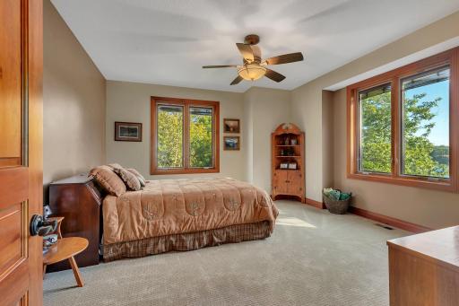 This spacious upper-level lakeside bedroom is the second of six bedrooms. It features large windows that showcase stunning views of the lake, filling the room with natural light and a tranquil ambiance.