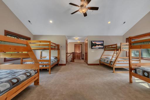 This huge bonus bunk room, the fourth of six bedrooms located on the upper level, is the perfect space, ideal for sleepovers, family gatherings, or a dedicated children's retreat designed for fun and relaxation.