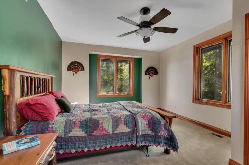 This upper-level lakeside bedroom is the sixth of six bedrooms, offering a private and quiet retreat. Large windows provide views of the lake and surrounding nature.
