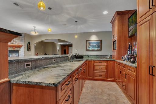 This stunning bar area has it all! Featuring a full stainless-steel refrigerator, dishwasher, and a built-in microwave. With tons of cabinet space for all your glassware and bar essentials, you'll be ready to host in style.