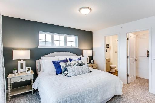 Another view of the primary suite and the attached walk-in closet and bath. Photo of end unit model, colors are similar.