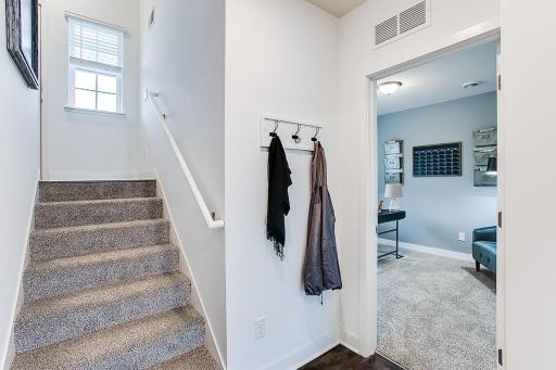 View from attached garage entry. Head upstairs or into the flex room. Photo of end unit model, colors are similar.